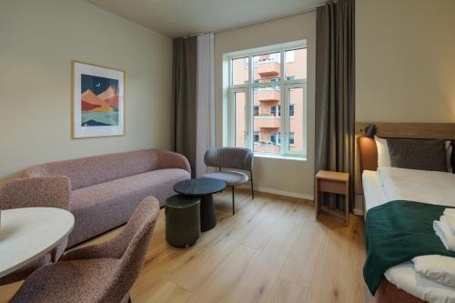 a living room with a couch and a bed at MAYA Apartments - Vika in Oslo