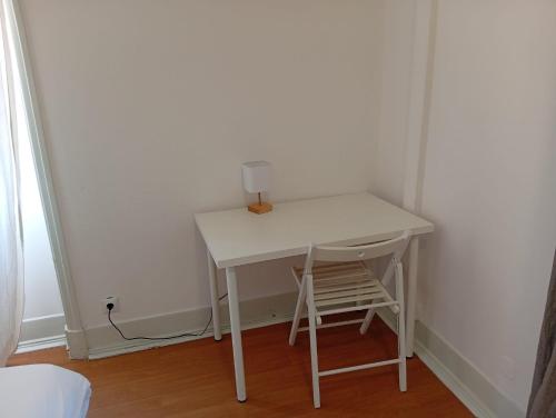 a small white table in a room with a chair at Residencial Sky Lounge in Lisbon