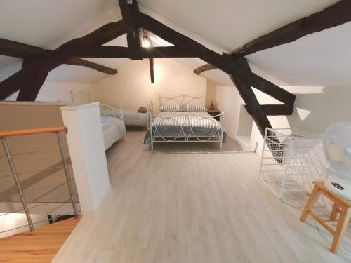 a bedroom with a bed in a room with wooden floors at Kinvara Gite in Dournazac