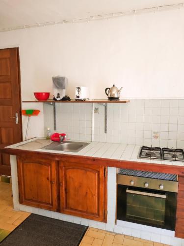 a kitchen with a sink and a stove at Appartement confortable à Sainte-Anne, 70m², vue jardin in Sainte-Anne