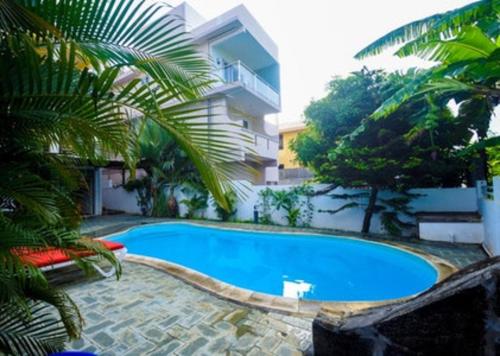 a large blue swimming pool next to a building at Modern Apartment in Pereybere + Pool in Pereybere