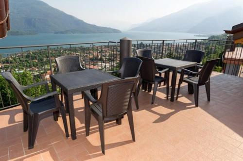 a group of tables and chairs on a balcony with a view at Lake View Apartment in Vercana, Shared Pool in Vercana