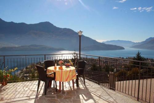 a table and chairs on a balcony with a view of the water at Lake View Apartment in Vercana, Shared Pool in Vercana