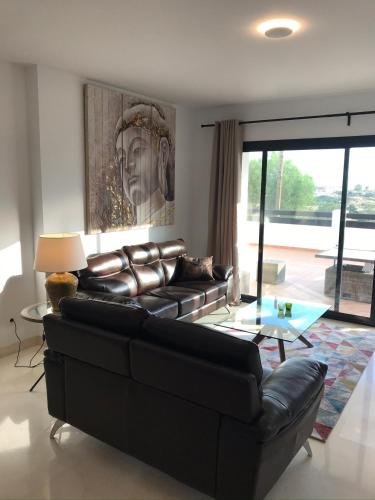 a living room with a black leather couch and a table at Spacious Apartment with Views in Málaga, 77 m², Shared Pool in San Luis de Sabinillas