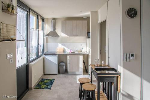 a small kitchen with a counter and stools in it at Studio confortable à Abondant, 30 m² avec jardin équipé in Abondant