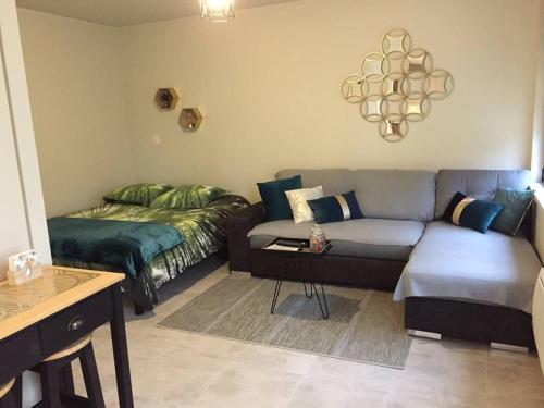a living room with a couch and a bed at Studio confortable à Abondant, 30 m² avec jardin équipé in Abondant