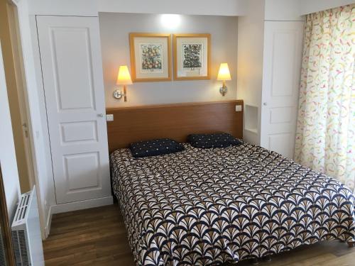 a bedroom with a bed and two pillows on it at Appartement cosy à Saint-André-des-Eaux de 47 m² avec jardin in Saint-André-des-Eaux