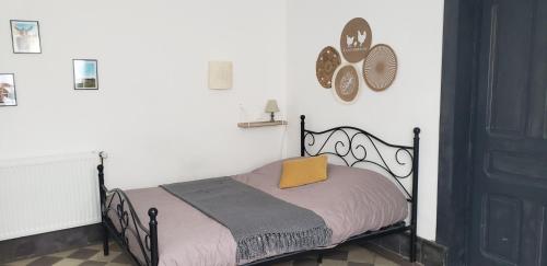 a bedroom with a bed with a yellow pillow on it at Studio - Le Saule in Foissiat