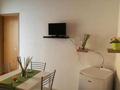 a room with a table and a television on a wall at Comfortable Villa in Ragusa with Pool in Trecasuzze
