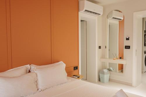 a bedroom with orange walls and a bed with white pillows at Dreamscape Central in Tirana