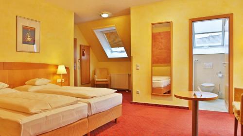 a hotel room with two beds and a mirror at Businesshotel HEILBRONN- Biberach in Heilbronn