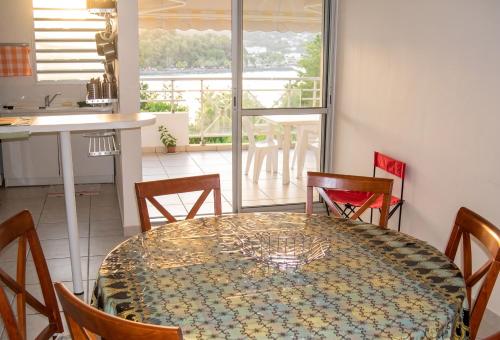 a dining room with a table and chairs and a kitchen at Appartement face à la mer à La Trinité – 70 m² – Terrasse in La Trinité