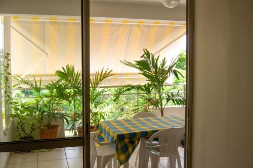 a table and chairs in a room with a window at Appartement face à la mer à La Trinité – 70 m² – Terrasse in La Trinité