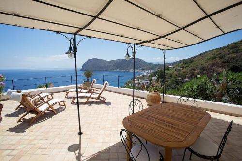 a patio with a table and chairs and the ocean at House with garden and sea view in Lipari in Lipari