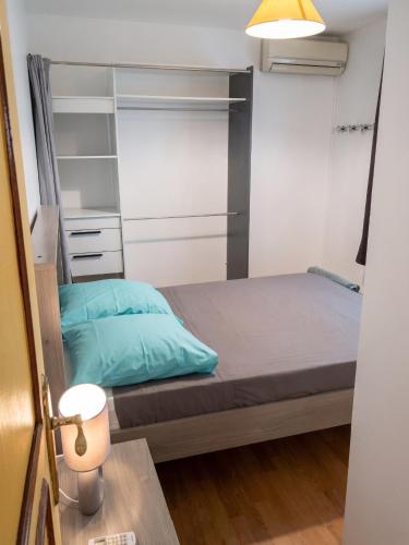a small bedroom with a bed and a lamp at Appartement lumineux aux Trois-Îlets in Les Trois-Îlets
