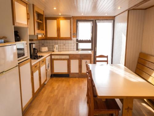 a small kitchen with a wooden table and a dining room at Chalet confortable à Giffaumont-Champaubert avec terrasse in Giffaumont-Champaubert