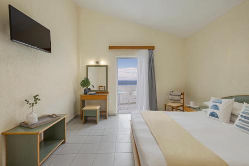 a hotel room with a bed and a view of the ocean at Porto Skala Village Hotel in Skala
