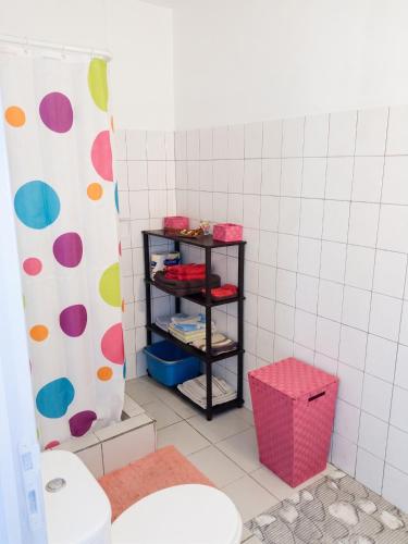 a bathroom with a toilet and a shelf with towels at Appartement confortable à Le Marin, jardin, 80 m², proche mer in Le Marin