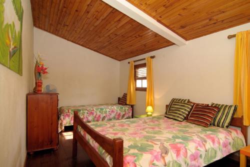 a bedroom with a bed and a wooden ceiling at Appartement confortable au Robert 70 m² avec jardin privé in Le Robert