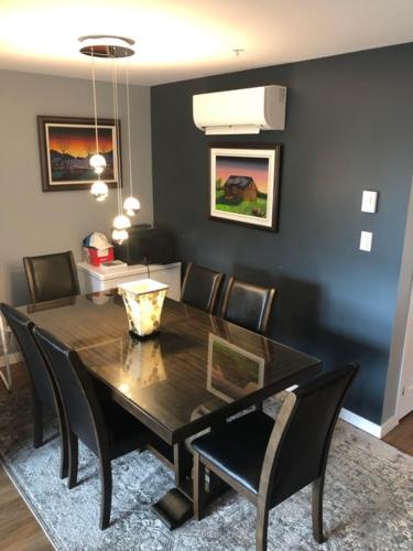 a dining room with a black table and chairs at Luxurious Apartment in Brossard with Terrace in Brossard