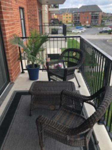 two chairs and a table on a balcony at Luxurious Apartment in Brossard with Terrace in Brossard