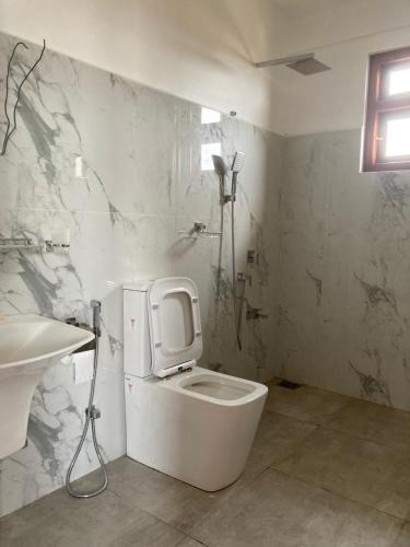 a bathroom with a white toilet and a sink at Jesuit Residence in Galle