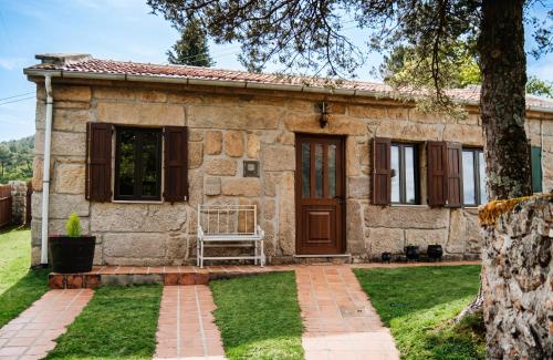 a stone house with a bench in front of it at Charming House in Sistelo + View in Sistelo