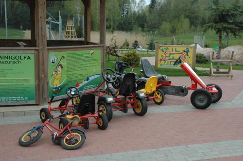 a group of four childrens tricycles parked outside a building at Majątek Giże Marczak in Olecko