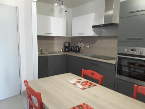 a kitchen with a table with chairs and a stove at Appartement cosy avec piscine privée à Métabief - 38 m² in Métabief