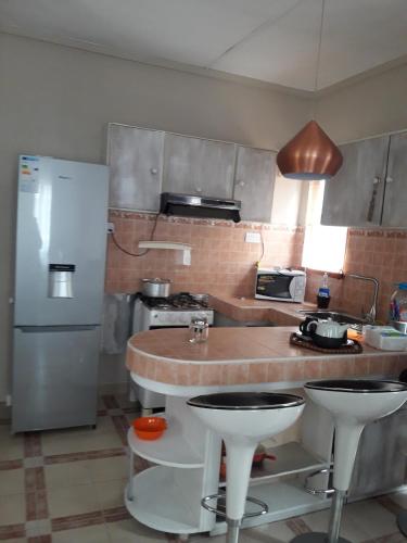 a kitchen with a counter and a refrigerator at Modern Apartment in Melville, Pool View, 120 m² in Grande Gaube