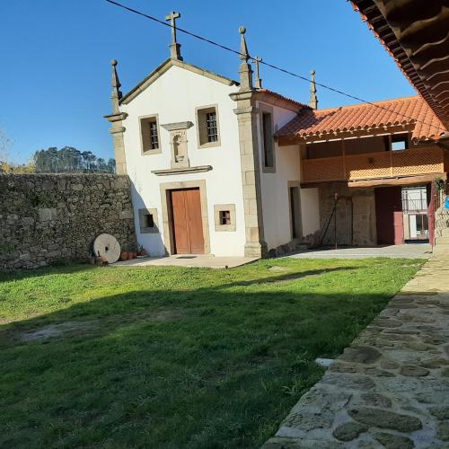 a church with a grassy yard next to a building at Beautiful villa in Póvoa de Lanhoso with pool and garden in Póvoa de Lanhoso