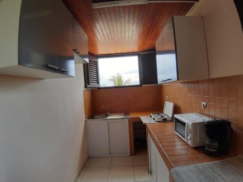 a small kitchen with a sink and a microwave at Appartement charmant à Sainte-Marie avec terrasse de 88 m² in Sainte-Marie