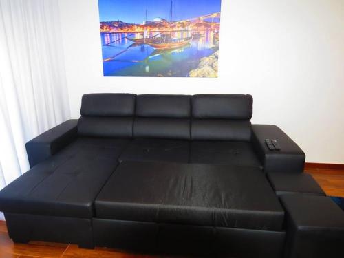 a black leather couch in a room with a picture at Elegant Villa in Porto with Pool & Jacuzzi in Porto