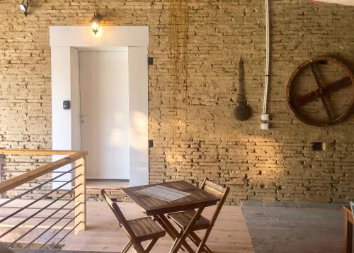 a table and chairs in a room with a brick wall at Studio charmant à Saint-Jory, 25 m², piscine partagée in Saint-Jory