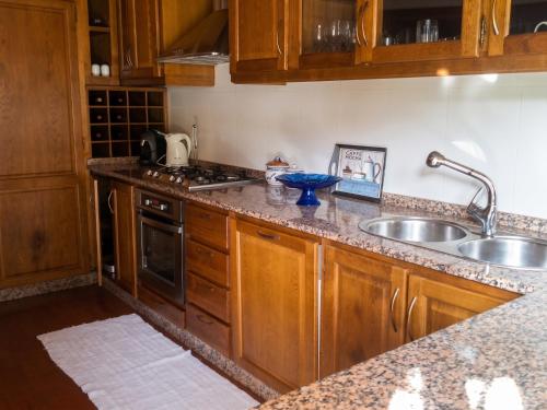 a kitchen with wooden cabinets and a sink at Elegant Villa with Panoramic Views in Caniçada in Caniçada