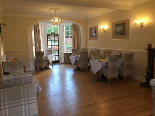 een eetkamer met tafels en stoelen en een kroonluchter bij Glentower Lower Observatory in Fort William