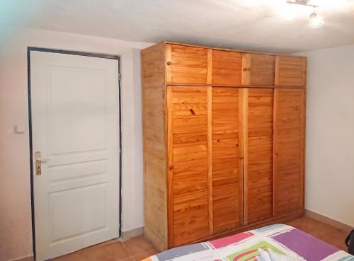 a bedroom with a wooden closet and a door at Appartement accueillant à Penne-d'Agenais - 32 m² - Terrasse in Penne-dʼAgenais