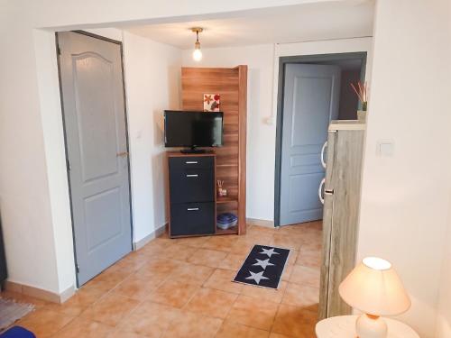 a room with a television and a room with a door at Appartement accueillant à Penne-d'Agenais - 32 m² - Terrasse in Penne-dʼAgenais