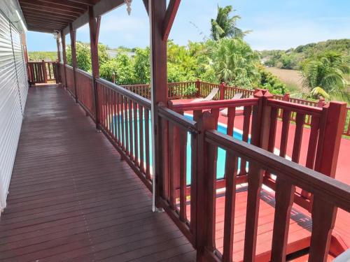 a wooden deck with a view of the water at Villa de charme à Sainte-Anne avec piscine privée in Sainte-Anne