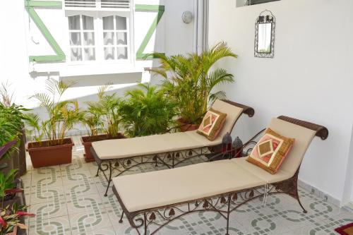 a balcony with two chairs and a window and plants at "Studio charmant à Deshaies avec piscine partagée, 20 m²" in Deshaies