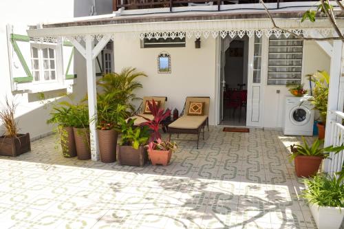 a patio with potted plants on a house at "Studio charmant à Deshaies avec piscine partagée, 20 m²" in Deshaies