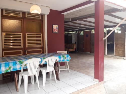 a table and chairs on a patio with a table and a table and chairsktop at Appartement moderne à Le Lamentin avec jardin clos, 110 m² in Le Lamentin