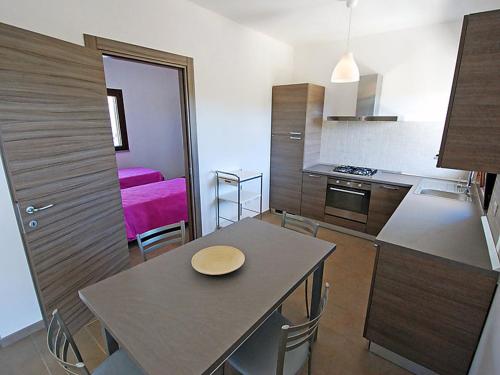 a kitchen and dining room with a table and chairs at Charming House in Is Potettus with Private Garden in SantʼAnna Arresi