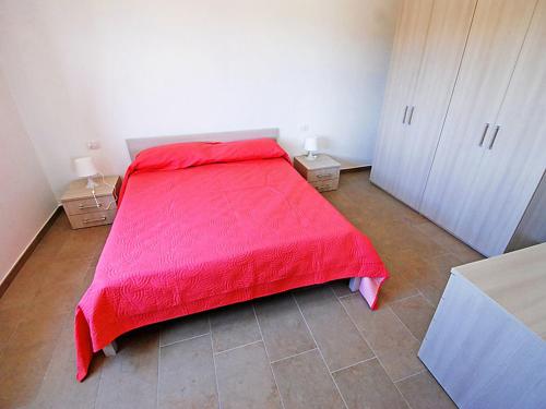a bedroom with a bed with a red blanket on it at Charming House in Is Potettus with Private Garden in SantʼAnna Arresi