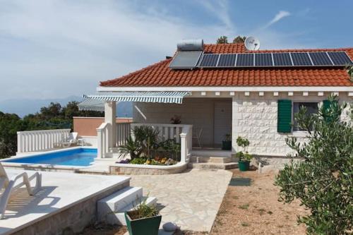 a house with solar panels on the roof at Charming Villa in Pučišća + Pool in Pučišća