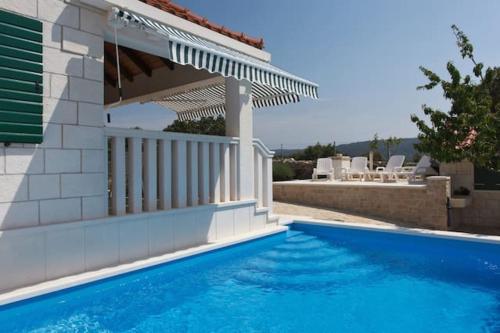 a swimming pool in front of a house at Charming Villa in Pučišća + Pool in Pučišća
