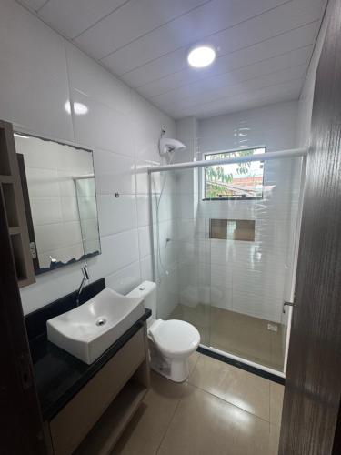 a bathroom with a toilet and a sink and a shower at Casa Completa em Picarras, Piscina, Sinuca e Churrasqueira in Piçarras