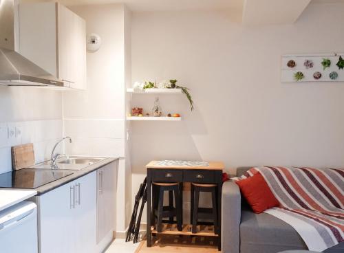 a small kitchen with a couch and a table at Charmant studio à Abondant avec terrasse ensoleillée - 30 m² in Abondant