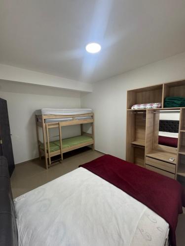 a bedroom with a bed and some wooden shelves at Casa Completa em Picarras, Piscina, Sinuca e Churrasqueira in Piçarras