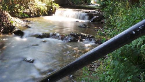 a river with a waterfall in the middle of it at Spacious chalet in Sibiel with mountain and lake views + Jacuzzi in Sibiel
